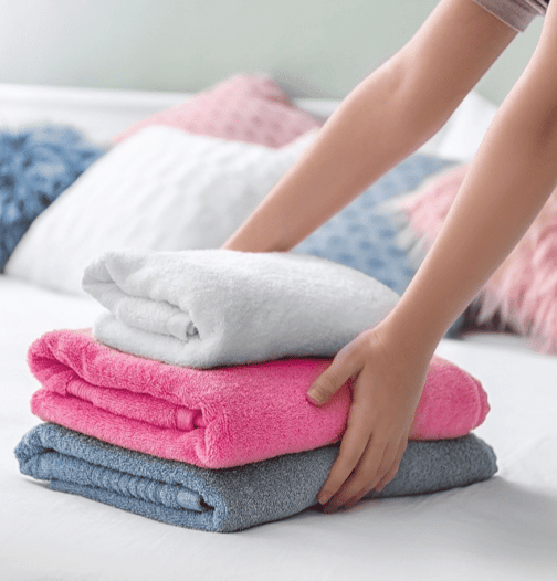 Folded Towels on Bed as part of housekeeping duties