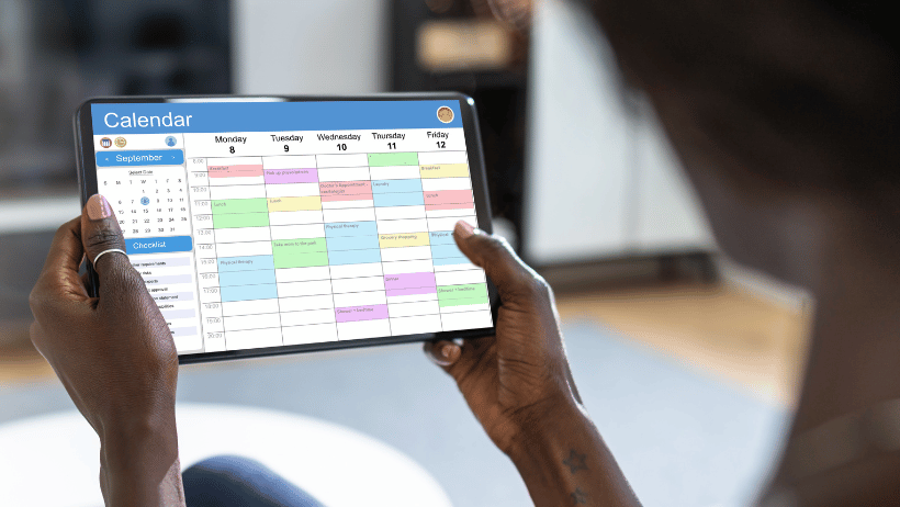 Woman holding a tablet with a family caregiving schedule